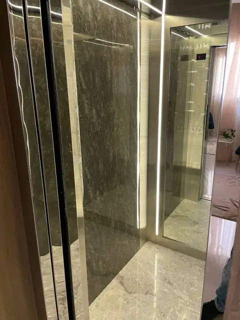Cabin with grey marble wall and LED strip, door open