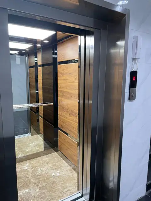 Cabin with wood panels, steel trim, marble floor and landing call button