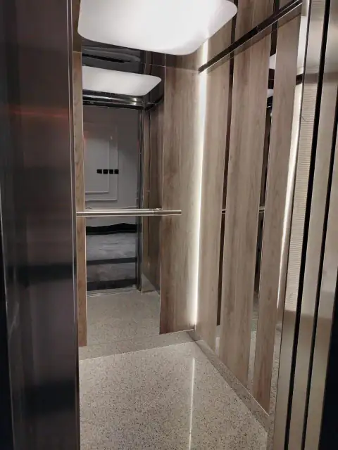 Cabin with wood panels, vertical steel strips and terrazzo floor