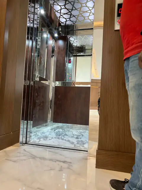 Cabin with lattice ceiling and wood panelling, technician beside the door