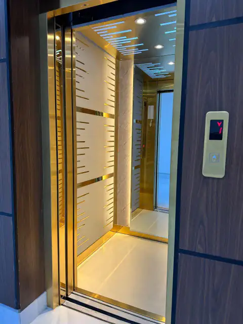 Cabin with gold trim, white panels and digital call button