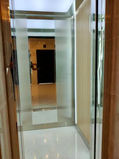 Glass-door cabin with wood sides and white marble floor
