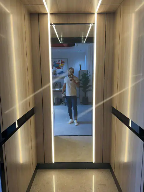 Narrow cabin with wood panels, LED strips and mirror back wall