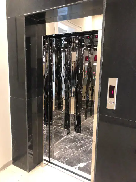 Black marble surround with mirror-steel cabin and wavy panels