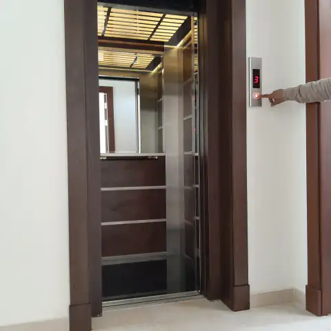 Wood-framed landing door with call button pressed