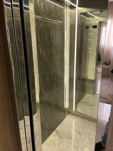 Cabin with grey marble wall and LED strip, door open