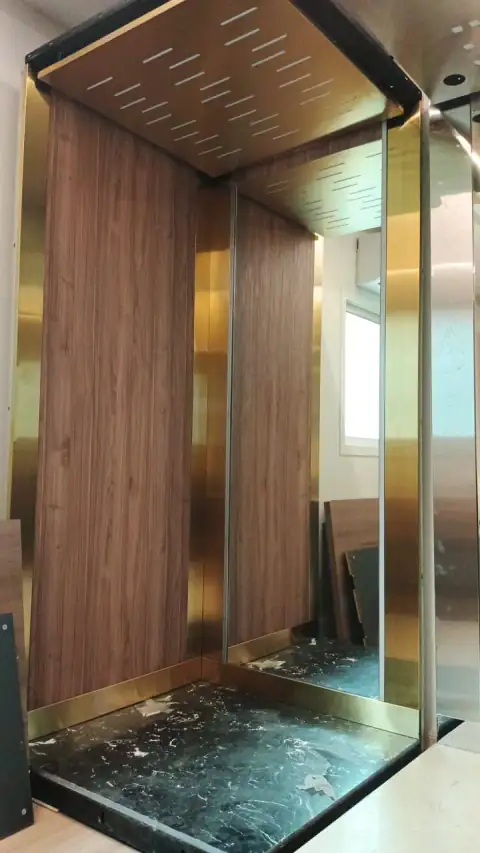 Cabin under finishing: wood and brass panels, glass floor not yet cleaned