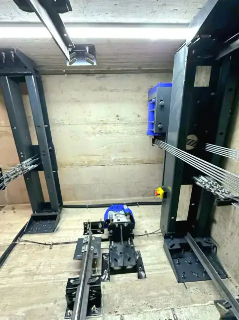 Machine area with steel columns, blue motor and ropes