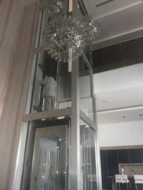 Technician on the glass car under a chandelier
