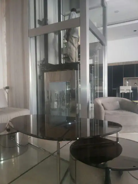 Glass lift in a living room, technician working on the car